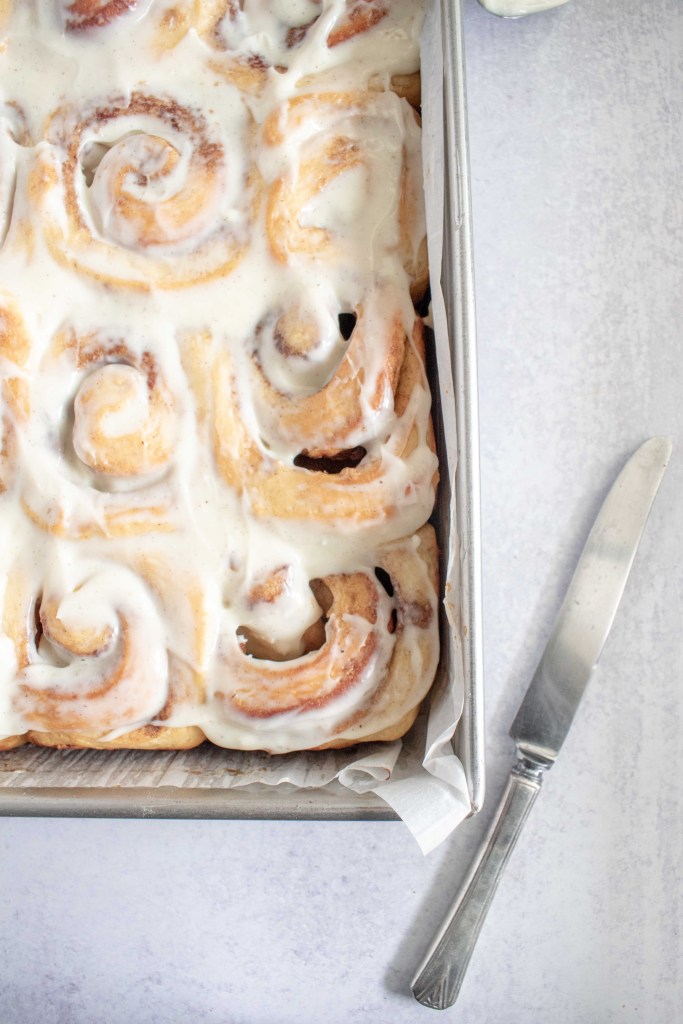 A closeup of the cinnamon rolls, styled next to a knife