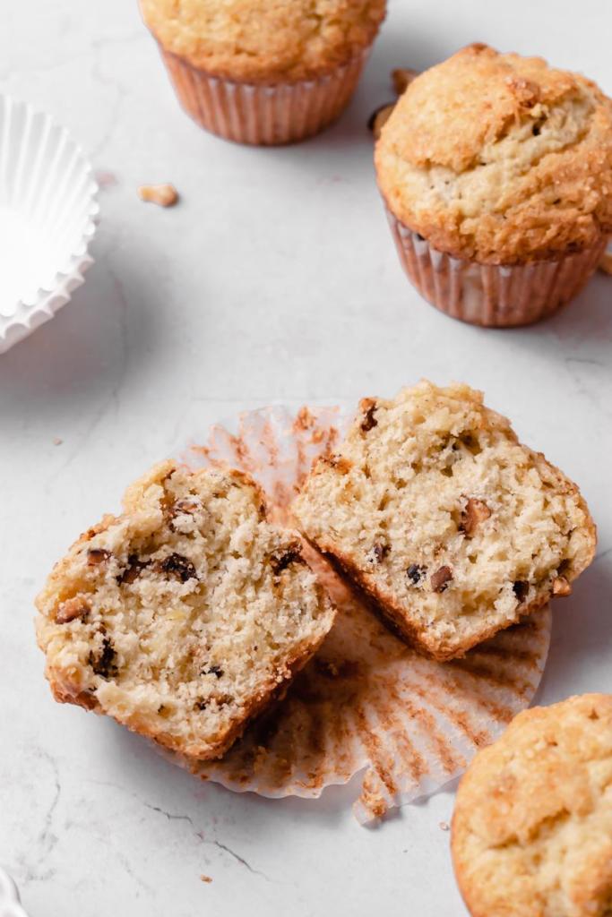 flat lay of the cross section of one of the muffins, three other muffins are surrounding it