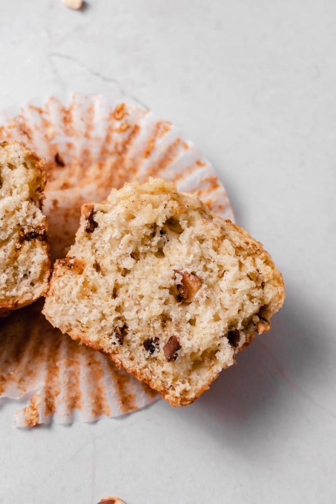 close up of a cross section of one of the banana muffins, laying on an opened muffin liner