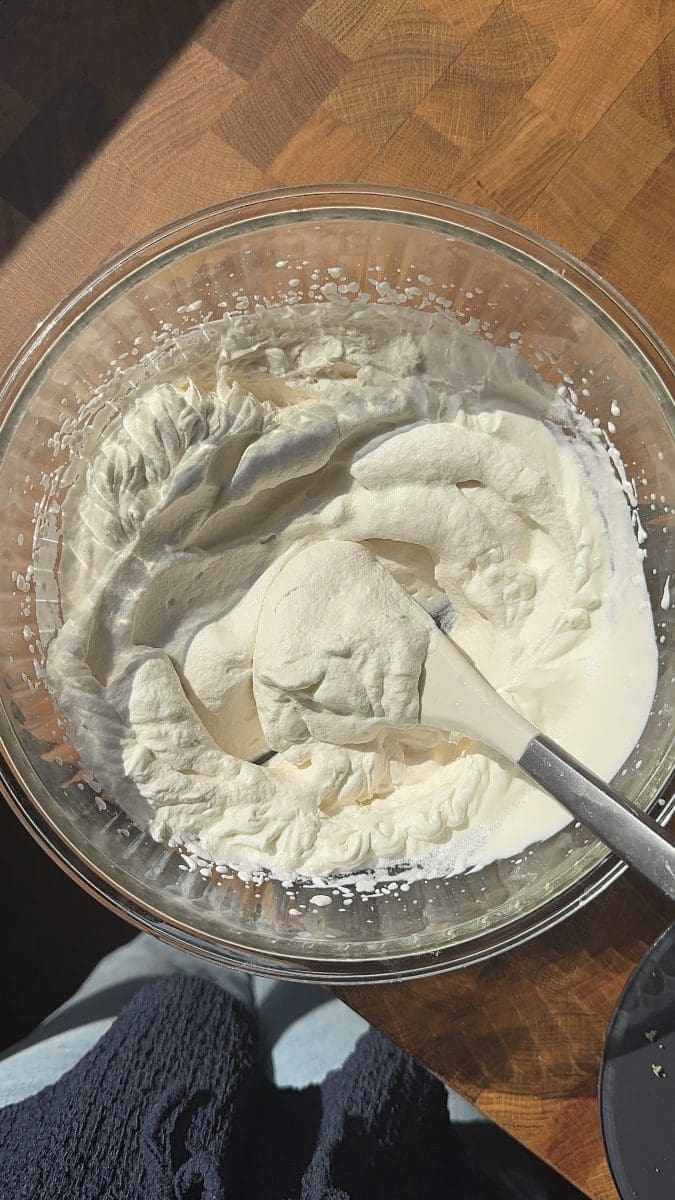The whipped cream in a mixing bowl.