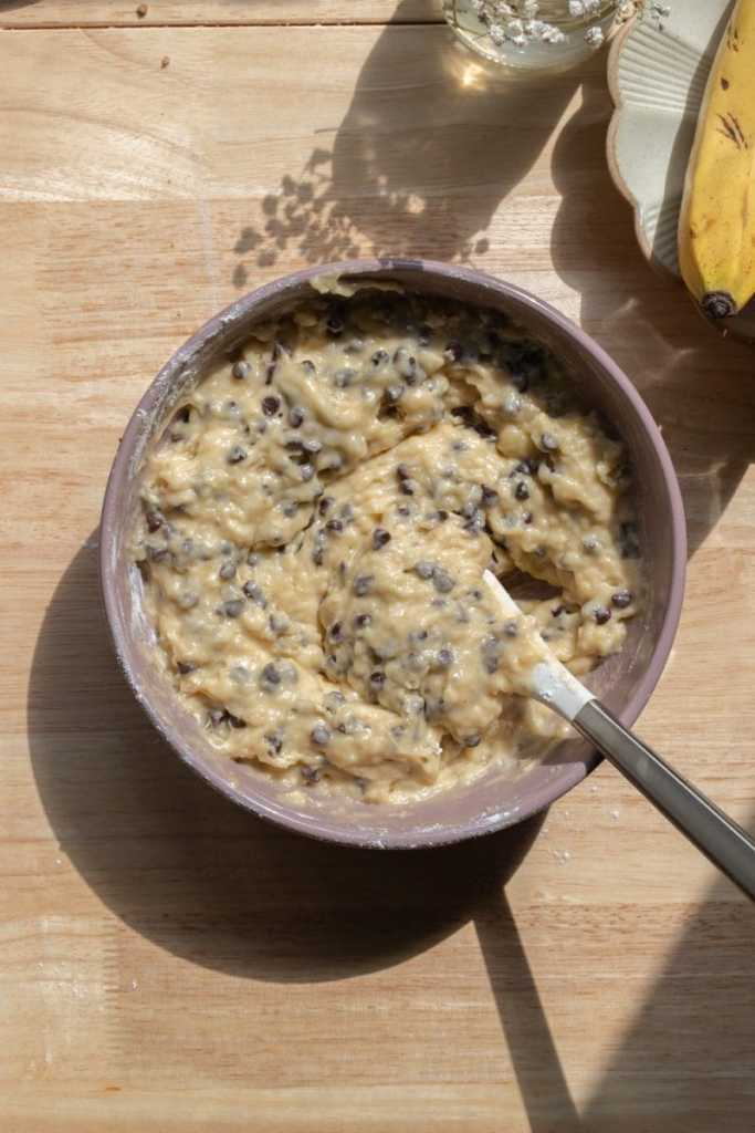 The finished banana muffin batter in a mixing bowl.