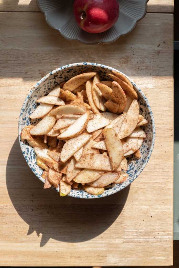 Chai-spiced apple slices in a small mixing bowl.