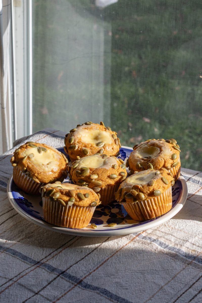The pumpkin cheesecake muffins sitting on a plate.
