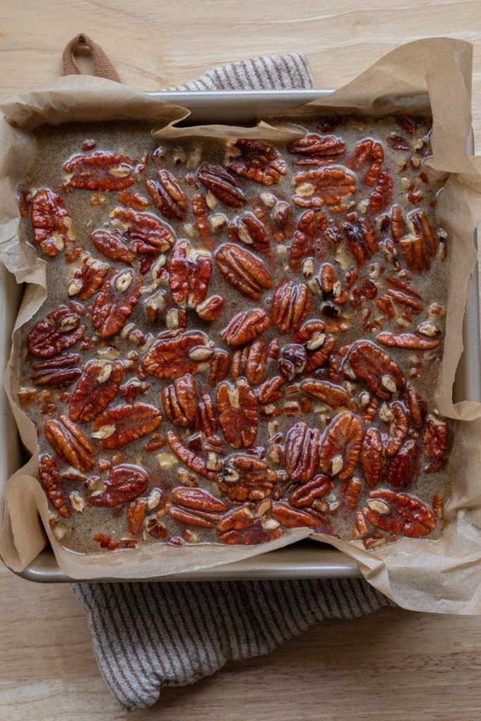 The pecan pie filling over the brownies.