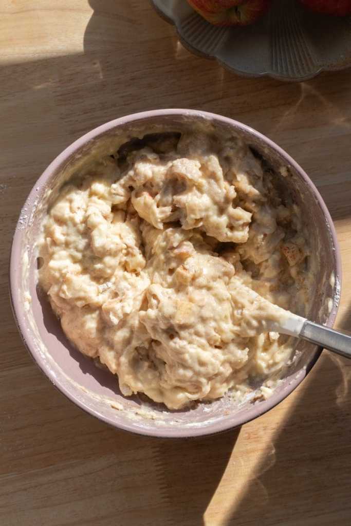 The finished apple crisp muffin batter in a mixing bowl.