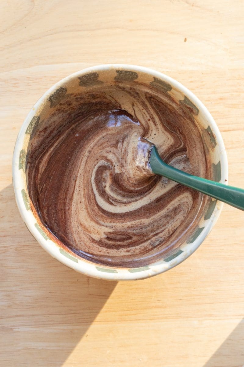 Folding the melted chocolate mixture into the egg mixture.