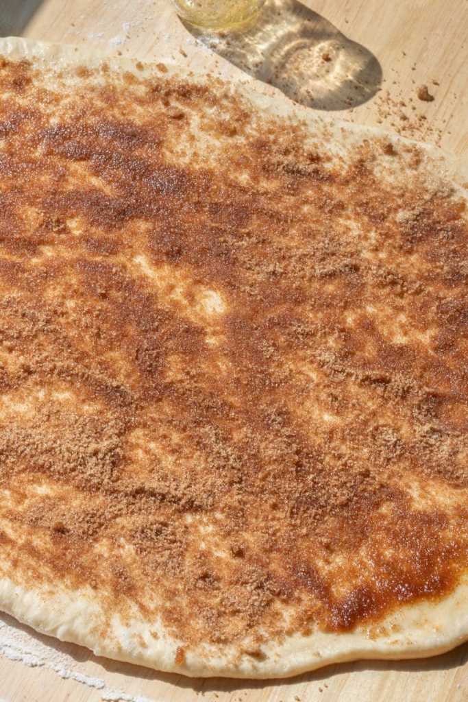 The cinnamon, sugar, and butter spread over the cinnamon roll dough.