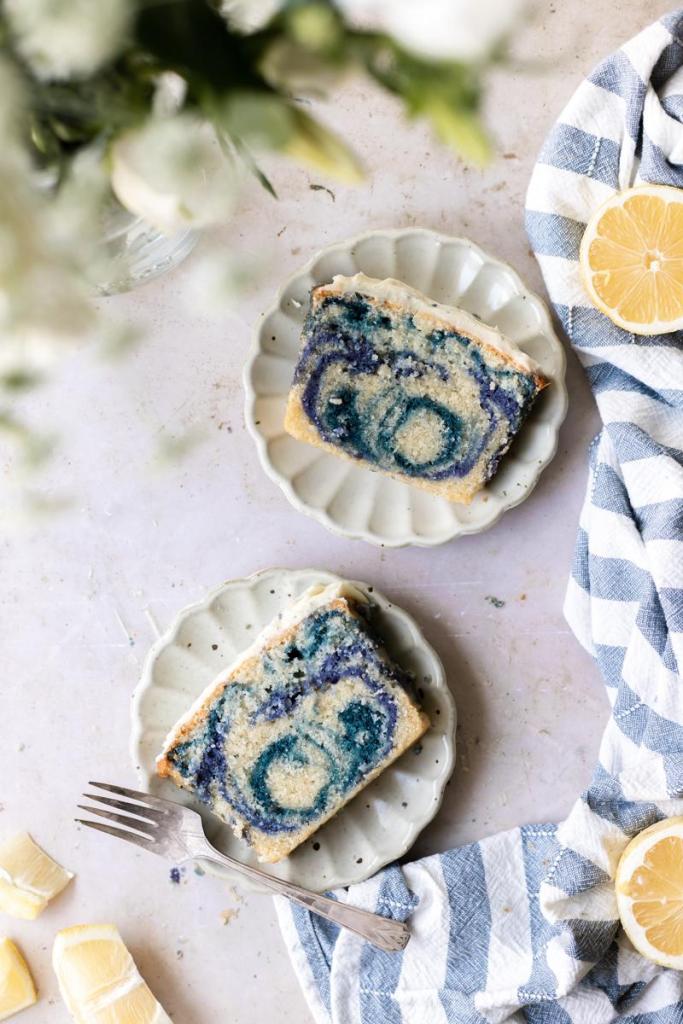 Flat lay of two slices of the magic butterfly pea flower loaf cake on plates.