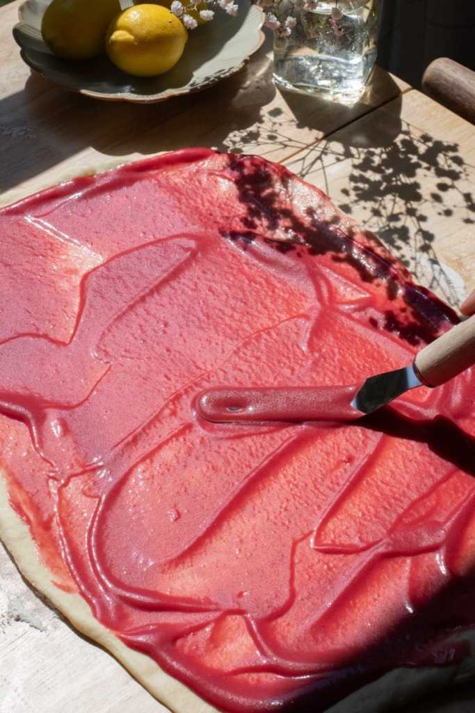 Spreading the raspberry curd over the dough.