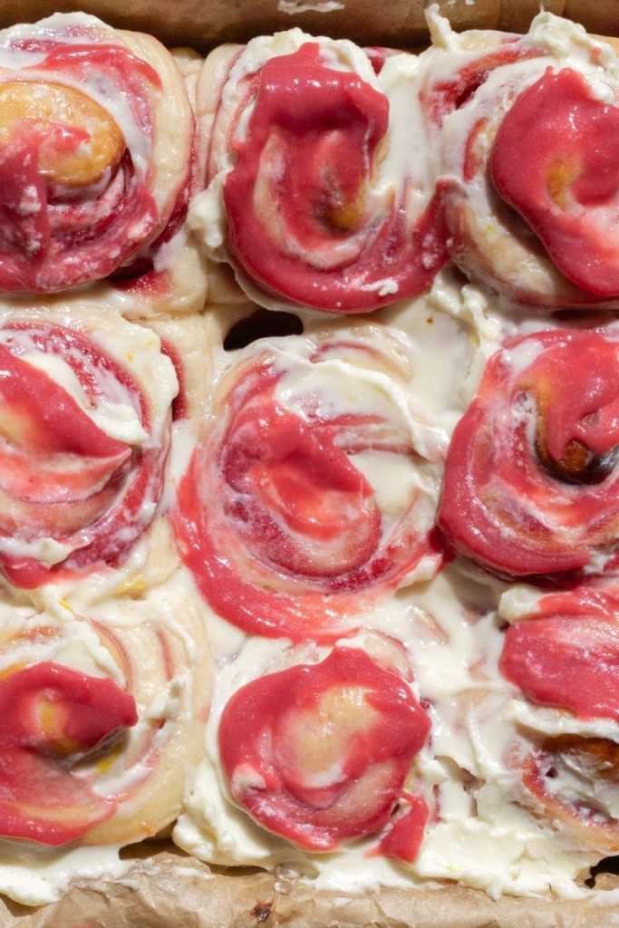 Close up of all of the frosted lemon raspberry rolls.