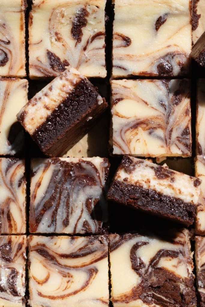 Close up of the cheesecake brownies with two slices facing towards the camera to show the cross-section.