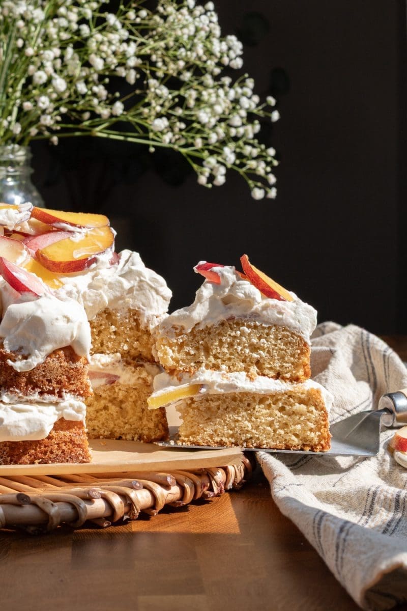 A slice of peach shortcake cake being pulled from the cake.