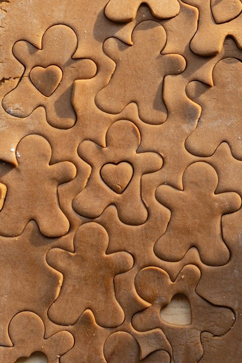 Cutting gingerbread cutouts out of the cookie dough.