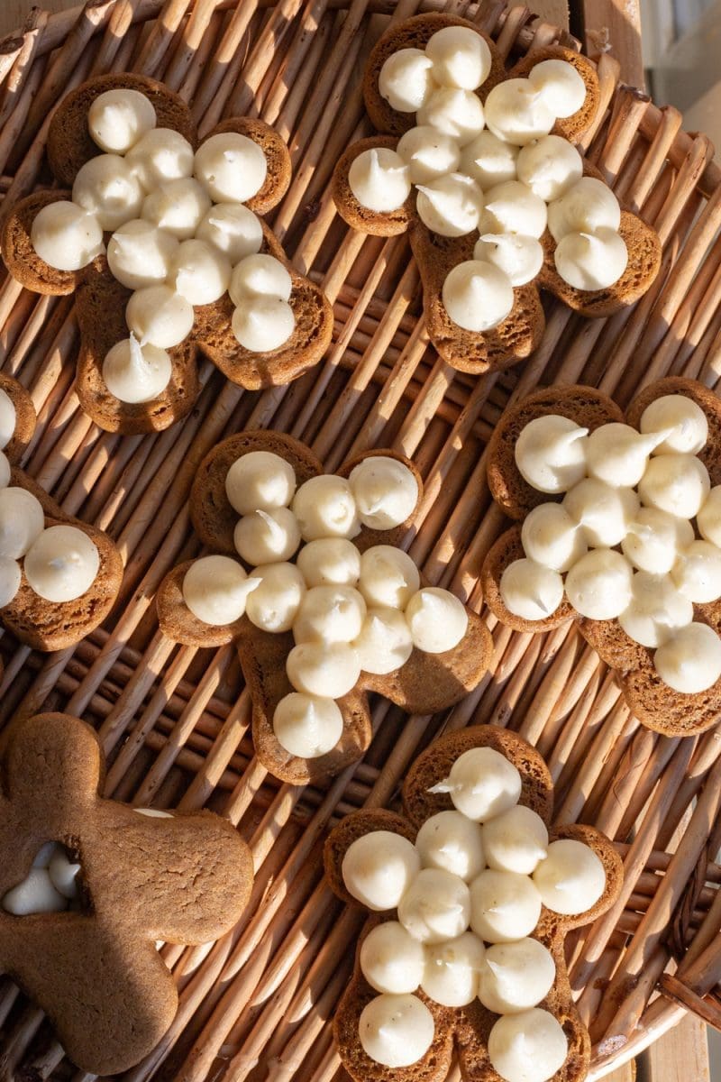 The sandwich cookies open-faced, with frosting piped onto them.