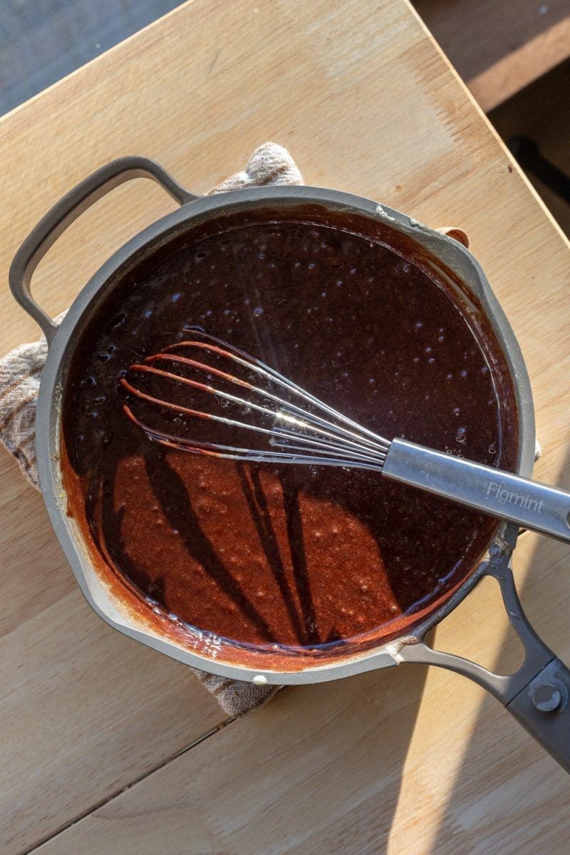 Chocolate, eggs, and sugar all mixed together in a saucepan.