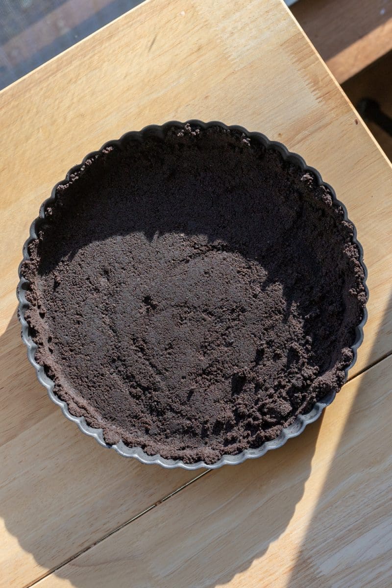 The oreo crust pressed into a tart pan.