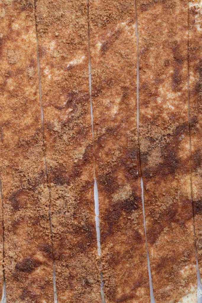 The dough topped with butter, cinnamon and sugar, sliced into strips.