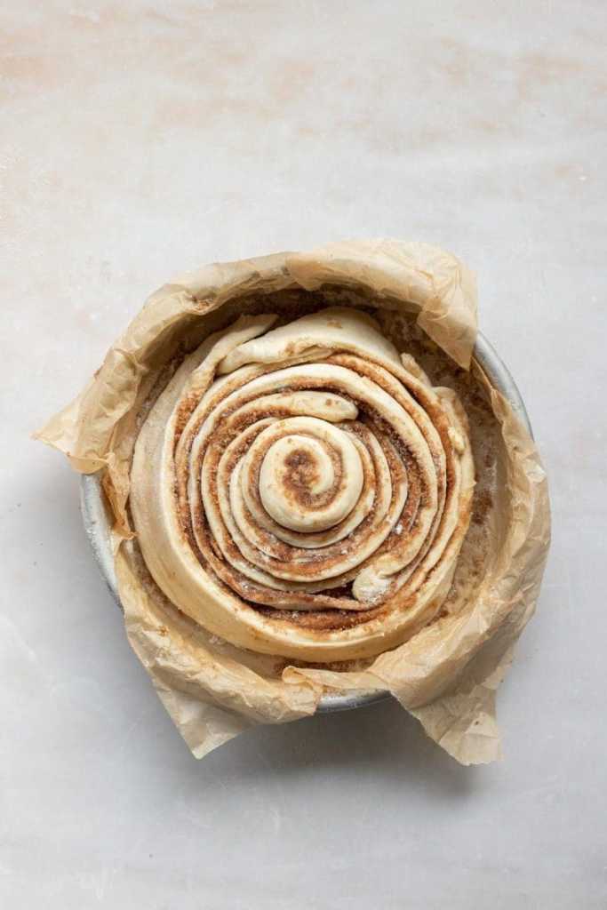 The giant cinnamon roll cake in a baking pan, prior to baking.