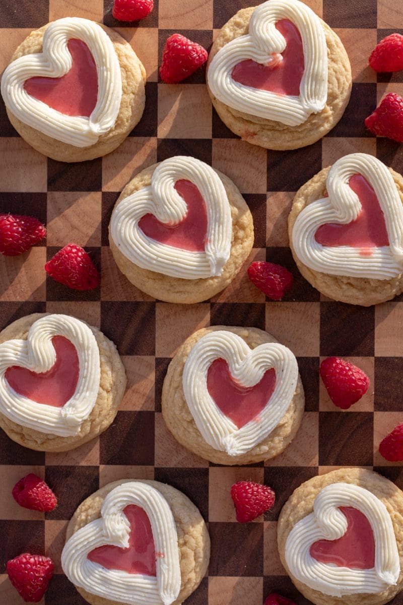 Raspberry curd sugar cookies layed out on a checkered platter.