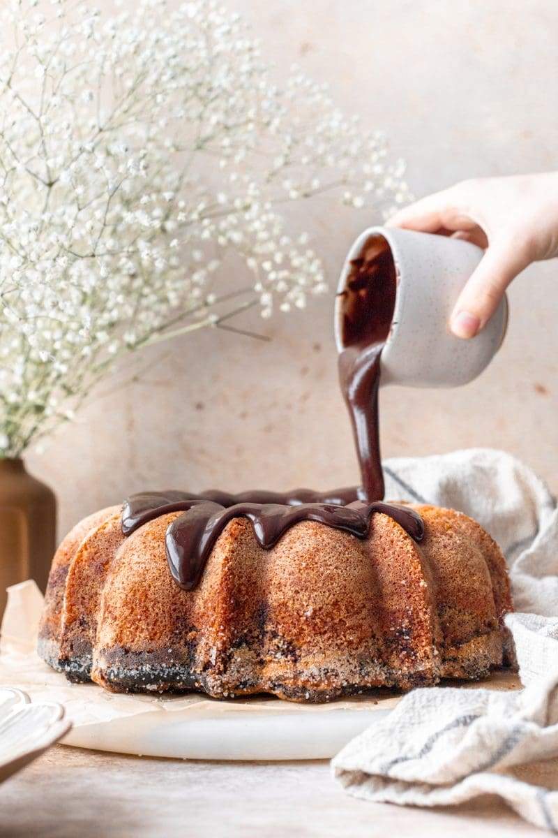 Pouring the chocolate icing on top of the bundt