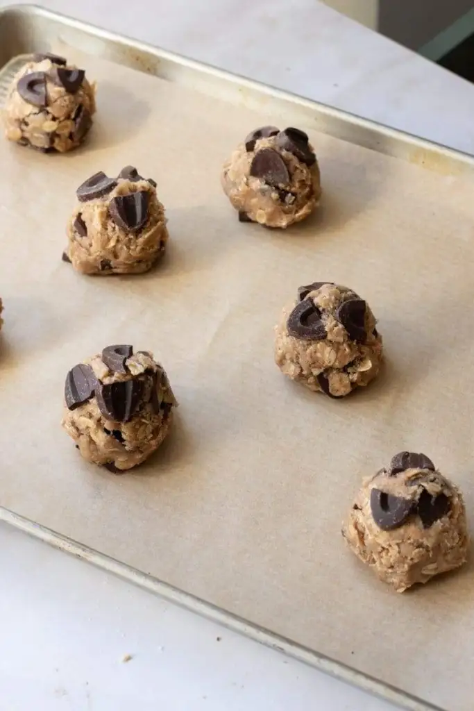 The cookie dough balls portioned out on a cookie sheet.