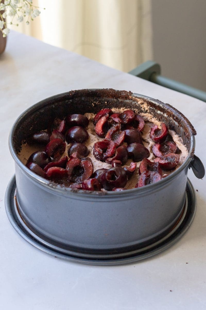 Assembling the chocolate cherry cake in the cake pan.