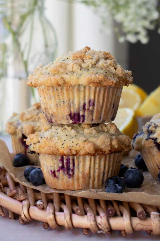 Two blueberry lemon poppy seed muffins stacked on top of each other.
