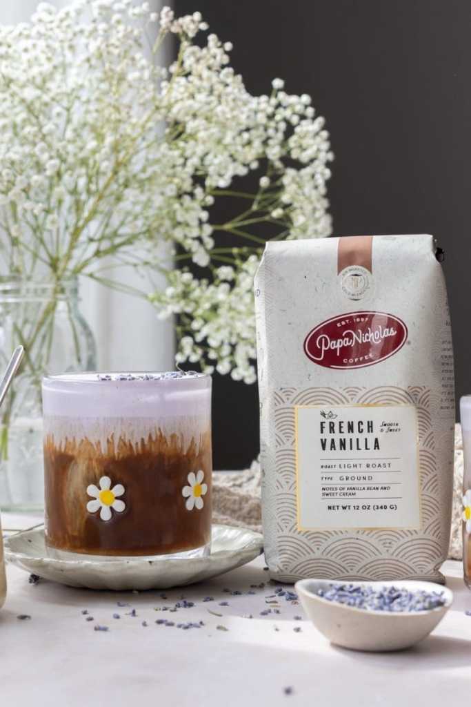 A cup of the lavender white chocolate iced coffee next to a bag of PapaNicholas French Vanilla coffee (sponsored.)