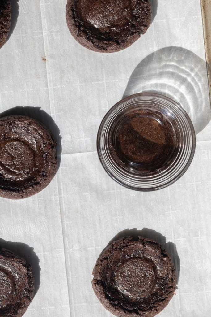 Using a bowl to press down on the cookies while they're still warm.
