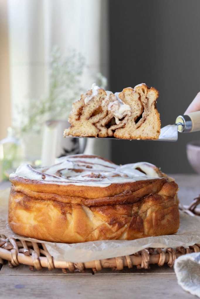 Lifting a slice of the cake over the whole cake.