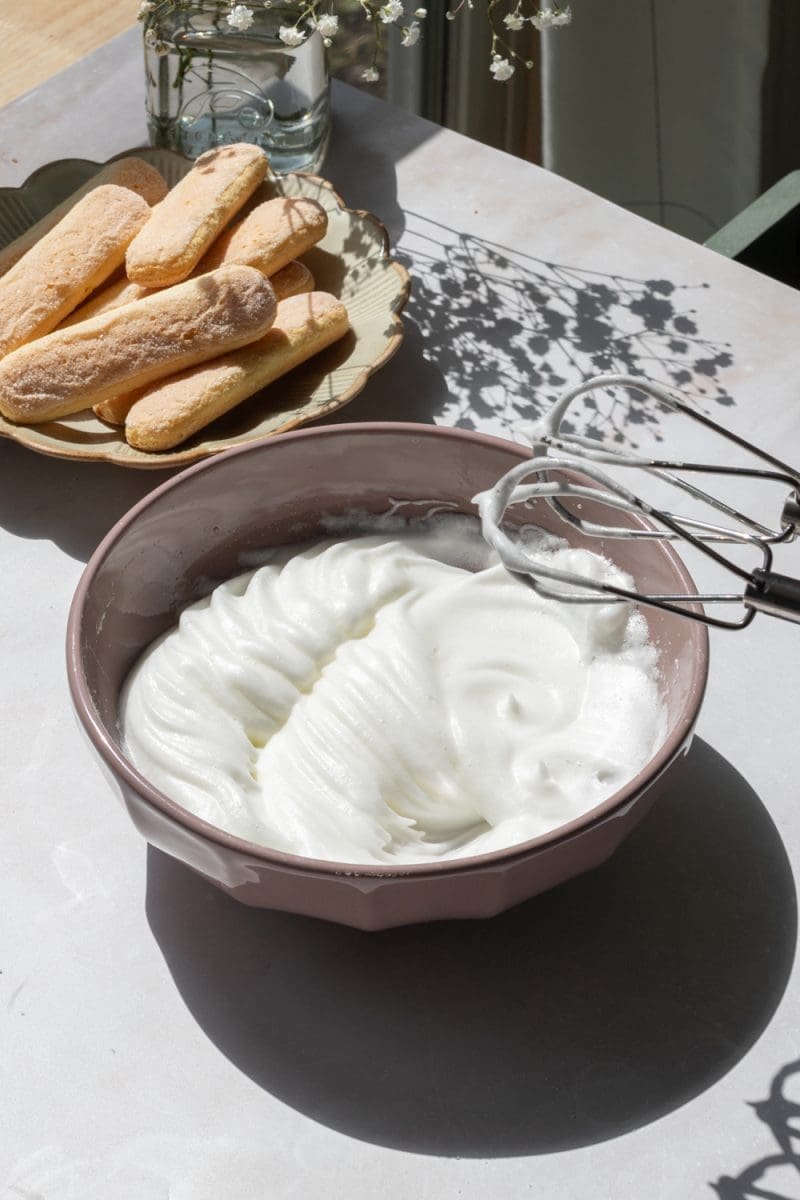 The whipped egg whites in a small mixing bowl.