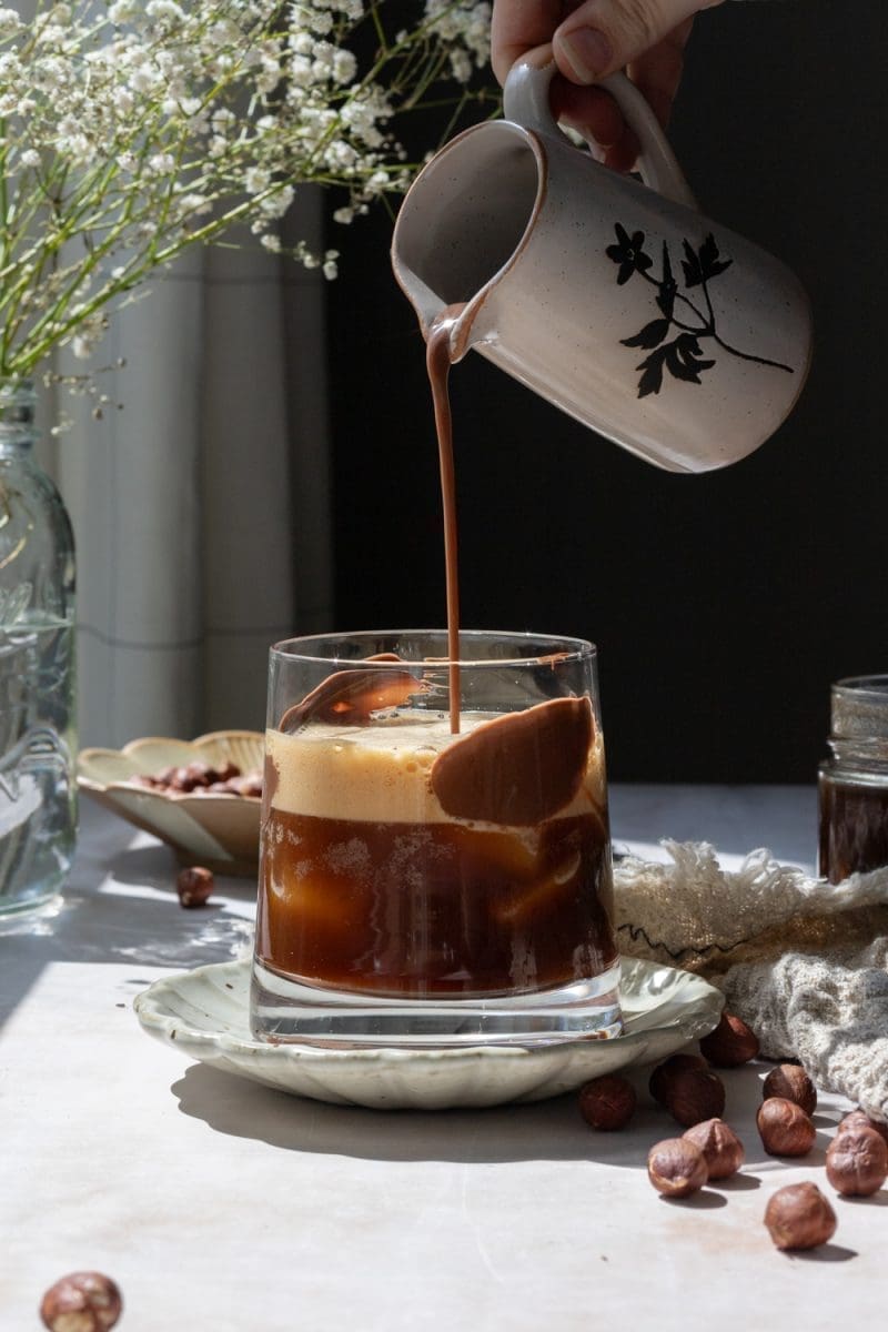 Pouring chocolate milk over the shaken espresso.