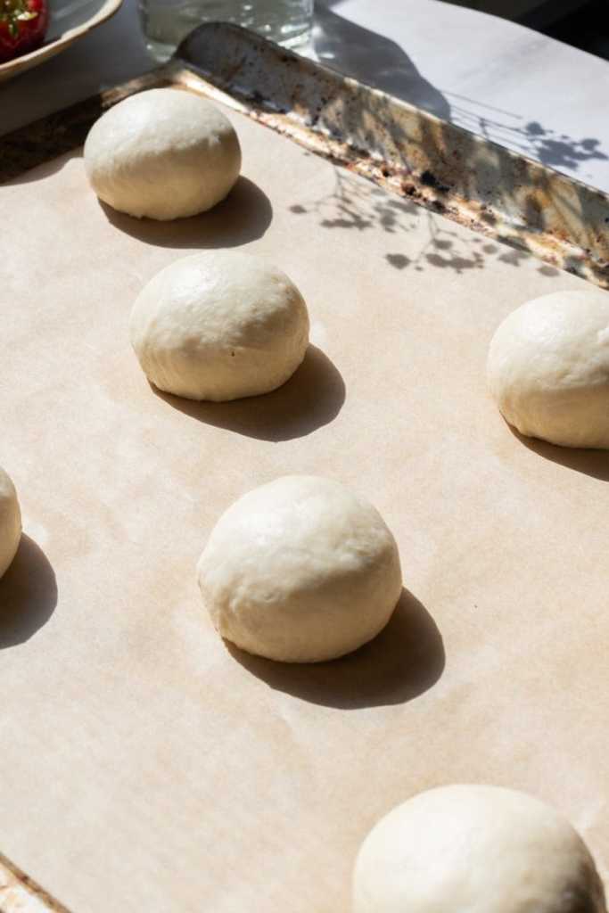 The dough balls on a baking tray.