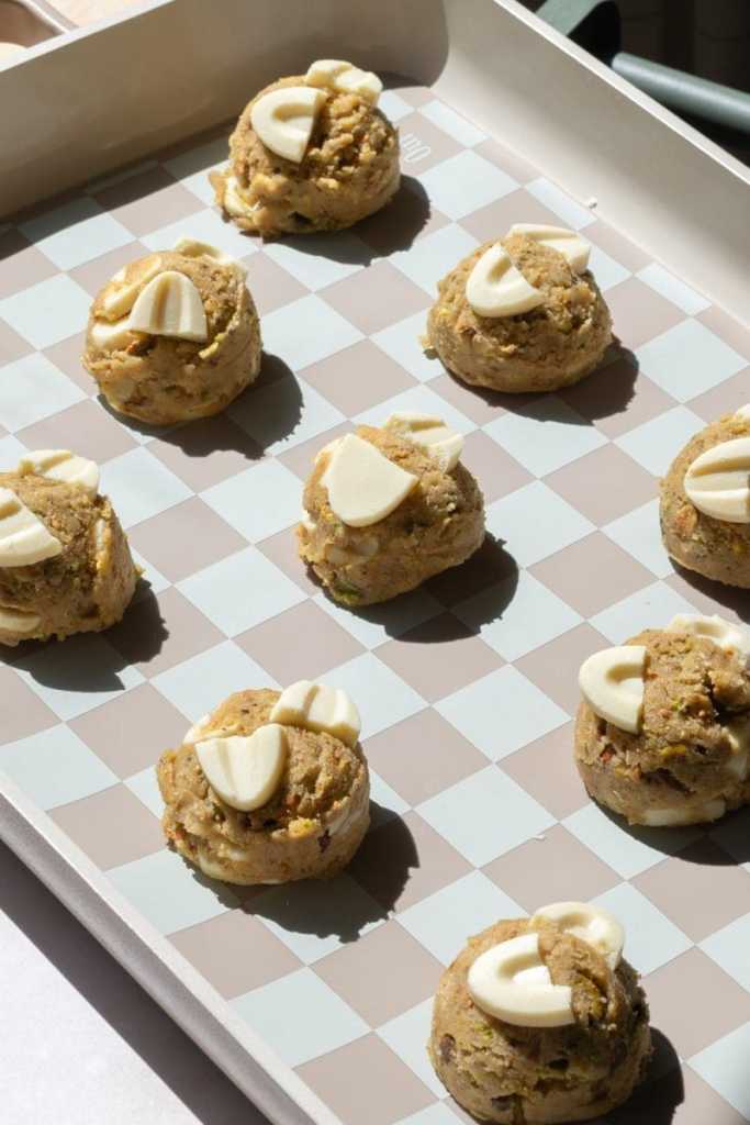 The pistachio cookies scooped out on to a baking tray.