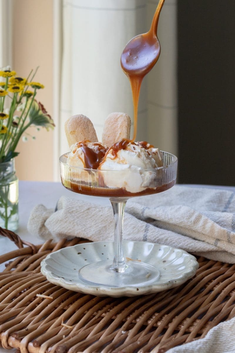 Pouring salted caramel over the ice cream.