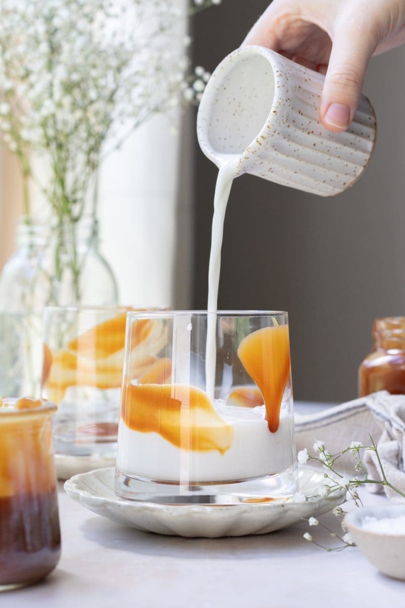 Adding milk into the cup.