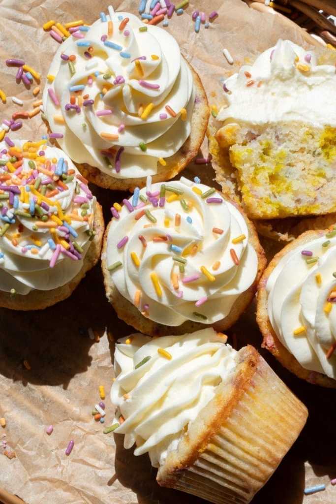 Confetti cupcakes in a circle, with one tipped over and one cut in half to show the cross-section