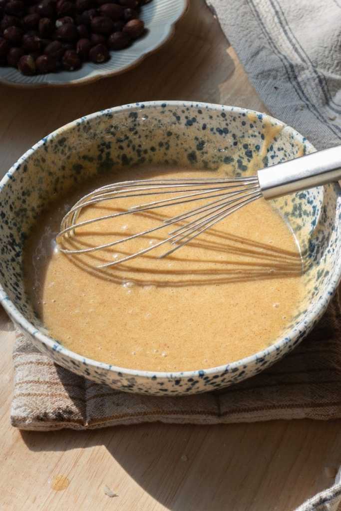 The egg and vanilla mixed into the cookie dough in a bowl.