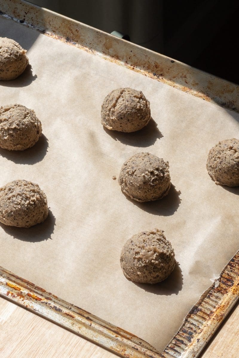 The cookie dough scooped out on to a parchment lined baking sheet.