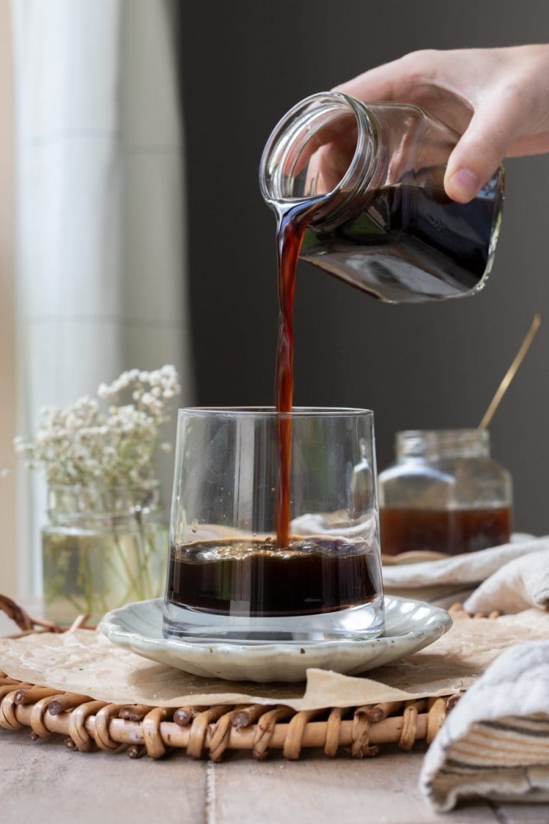 Pouring cold brew coffee into a cup.