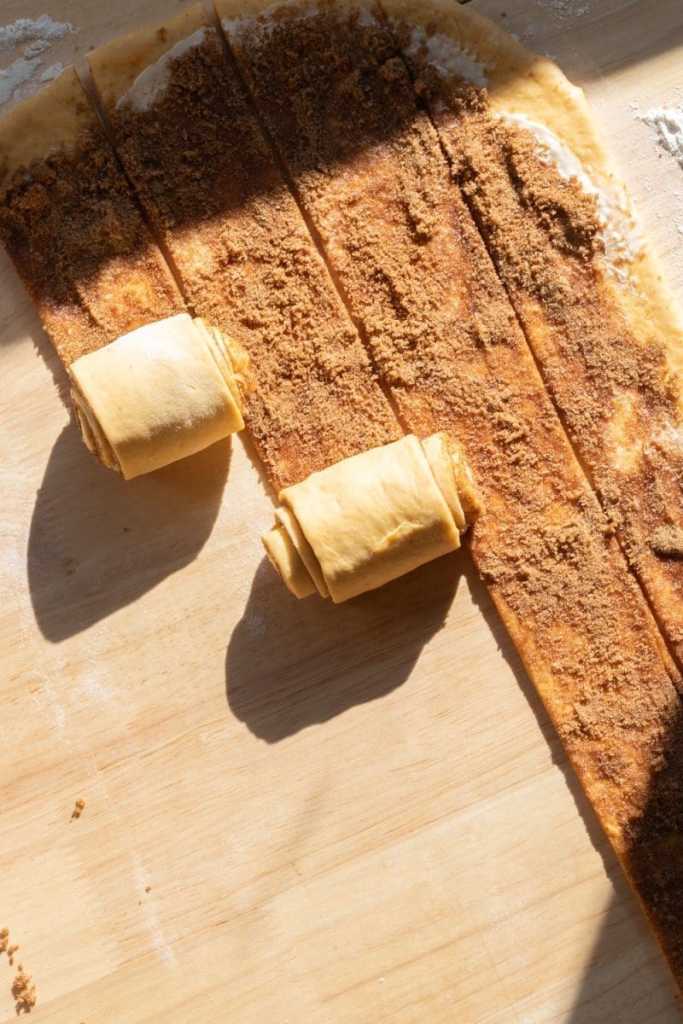 Rolling up the pumpkin cinnamon rolls.