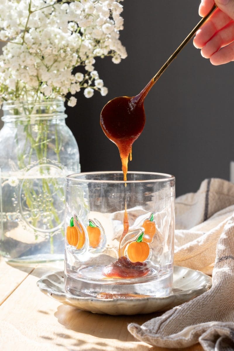Spooning pumpkin spice sauce into the cup.
