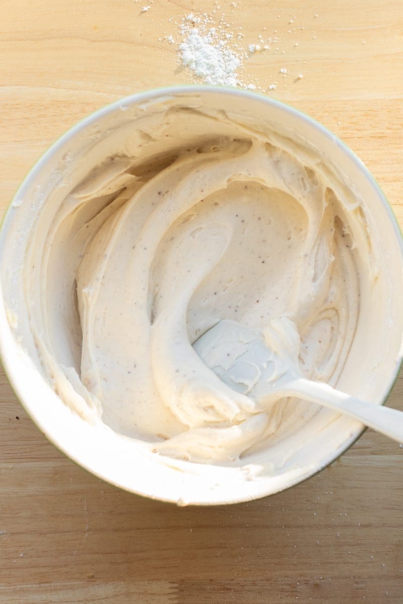 Mixing bowl with vanilla cream cheese frosting in it.