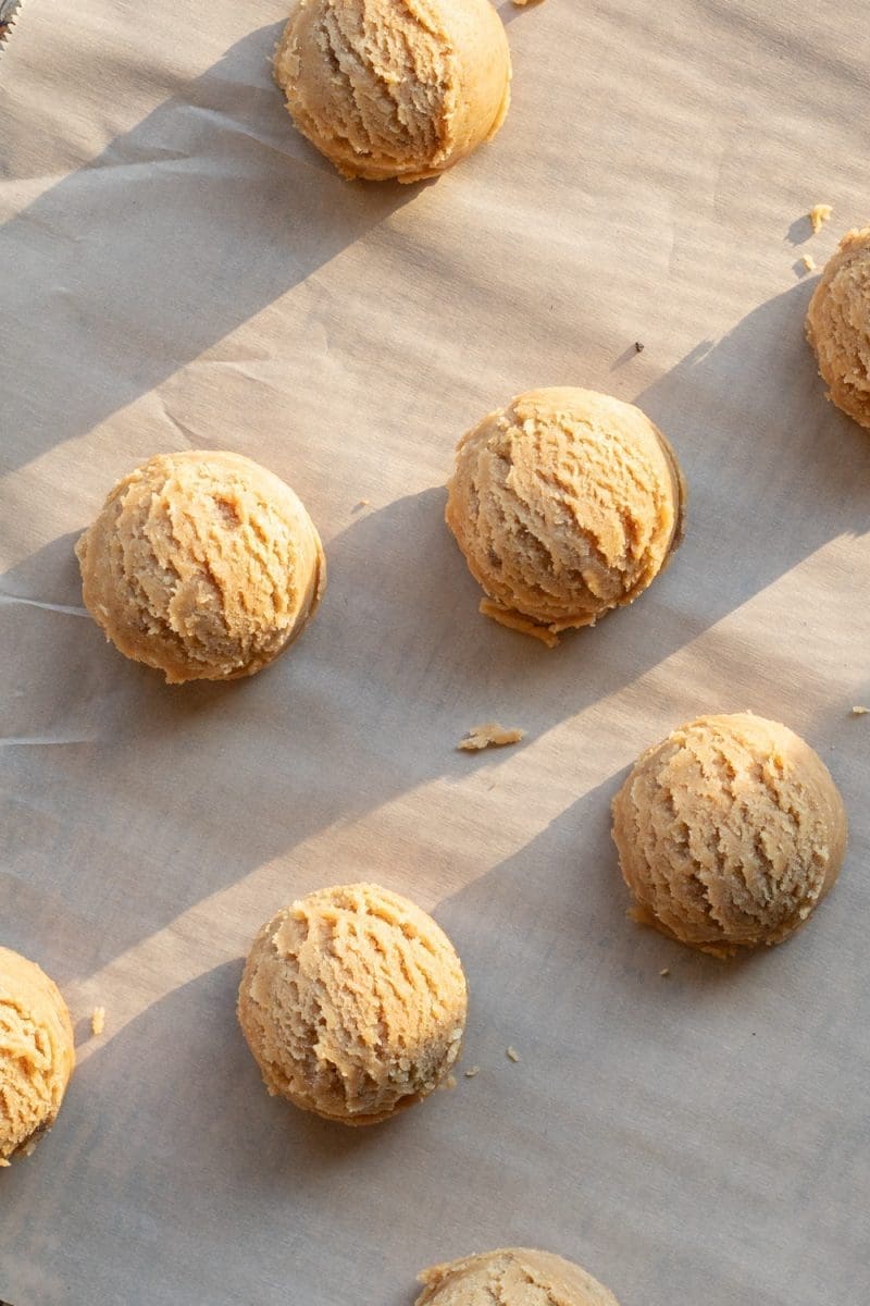 The cookie dough balls scooped out on a baking tray.