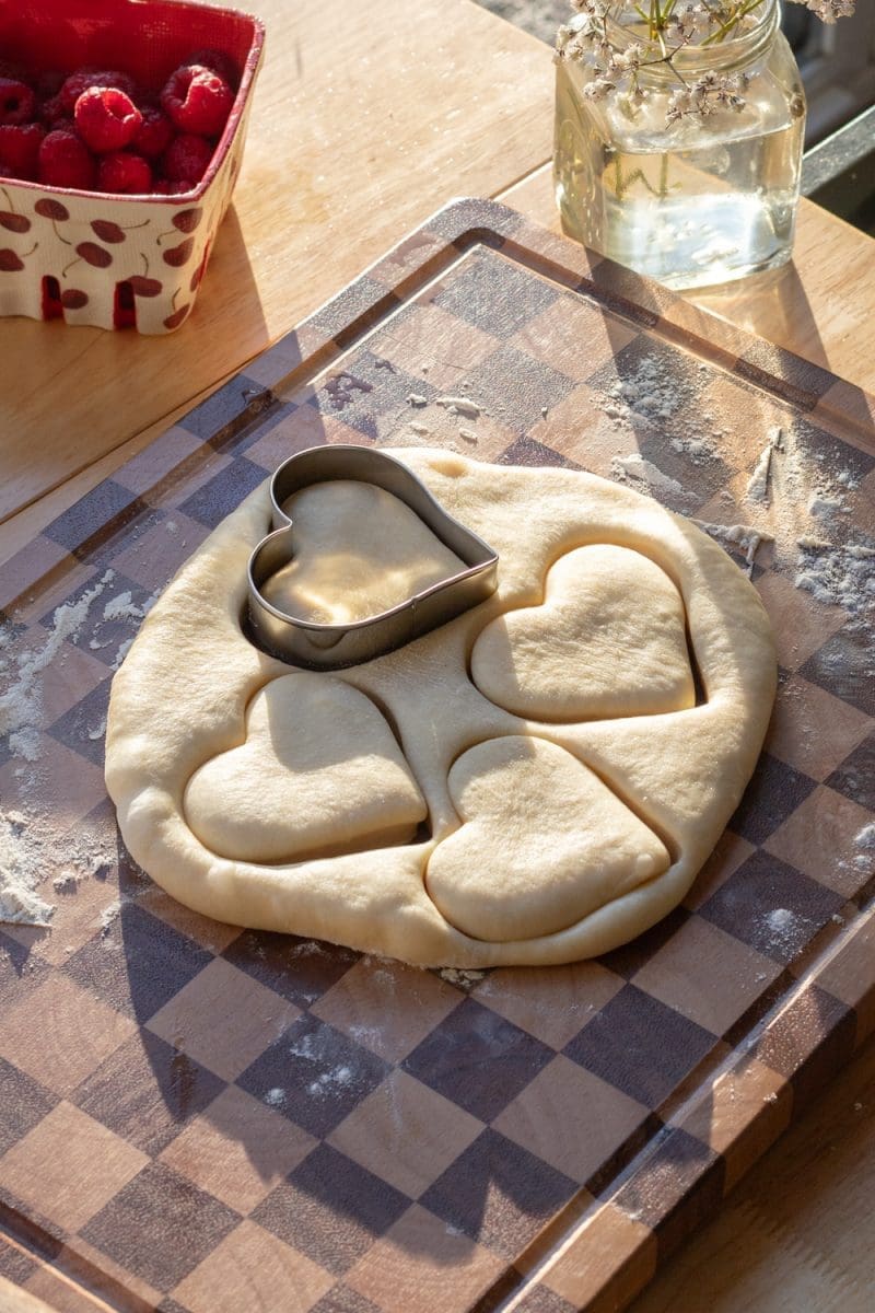 Cutting out hearts in the dough.