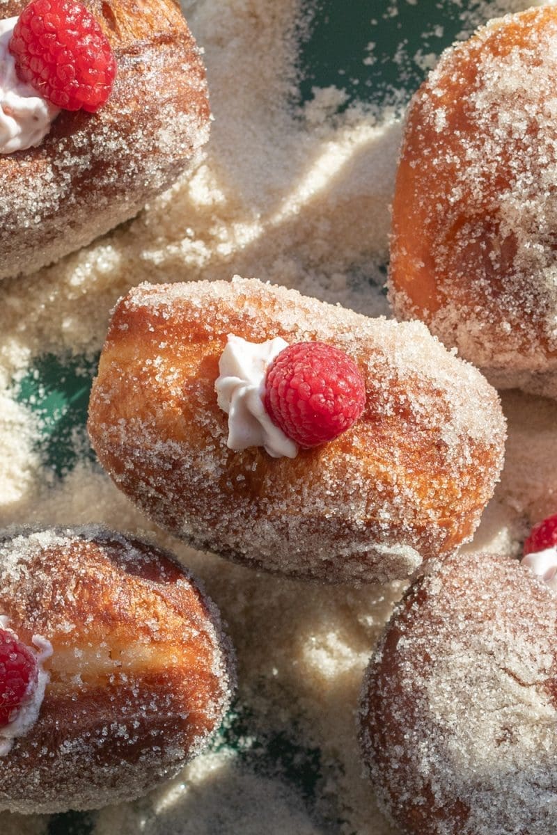 Close up of the tops of the filled raspberry cheesecake heart donuts.