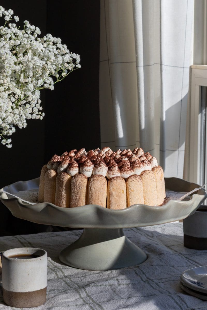 The tiramisu cheesecake on a cake stand.