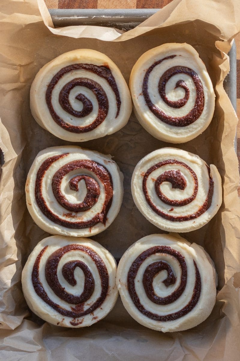 The rolls sliced up and sitting in a lined eighth sheet pan.