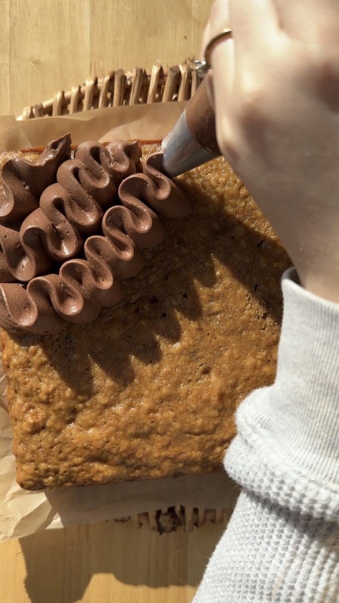 Piping the frosting on to the cake.