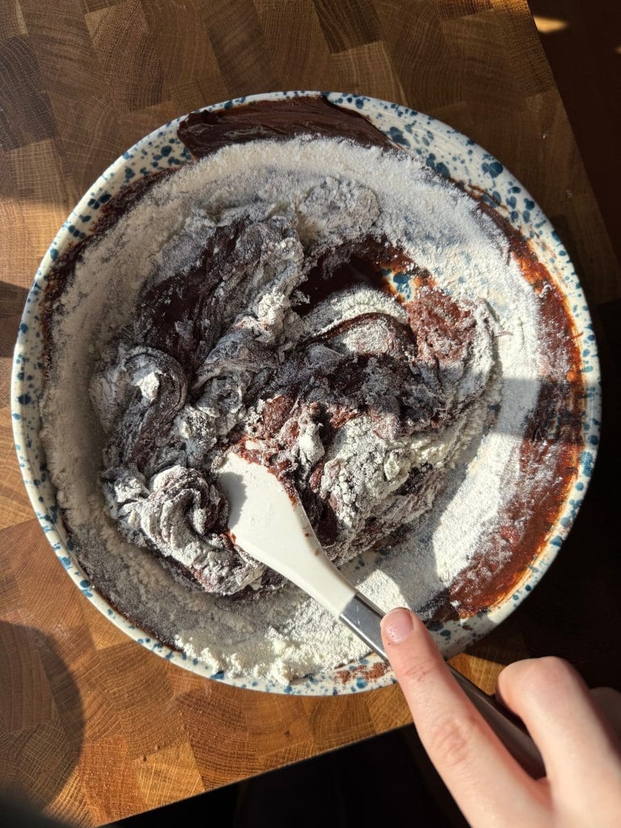 Folding the dry ingredients into the brownie dough.